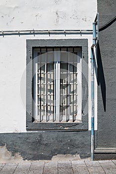 House with a white facade and a window with grill