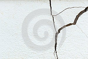 A house white wall with a large crack. Grunge concrete cement white wall with a crack in an industrial building