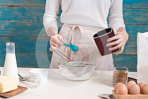 House wife wearing apron making. Steps of making cooking chocolate cake.