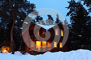 House in winter wood in twilight