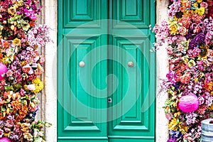 House with wooden door and colorful flowers