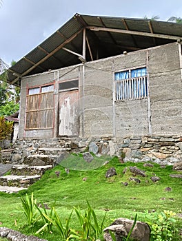 A house with a wooden frame, windows made of bamboo, and with walls that have not been plastered