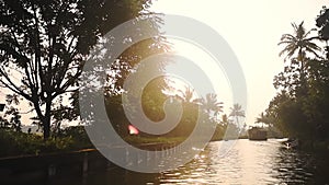 Houseboat floating on a river flowing near palm trees, Kerala Backwaters, India,