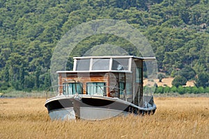 Houseboat in rushy shallow waters of bay