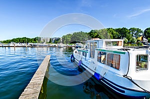 Houseboats and yachts are moored in Goehren-Lebbin Germany at a jetty of the lake Fleesensee