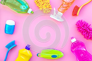 Housecleaner tools set with detergents, soap, cleaners and brush on pink background top view mock up