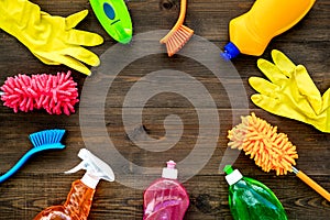 Housecleaning with detergents, soap, cleaners and brush in plastic bottles on wooden background top view mockup