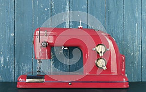Household appliances - Front view retro red sewing machine wooden background