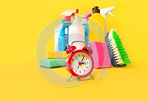 Household chemicals and alarm clock background.  Saving time with cleaning service concept