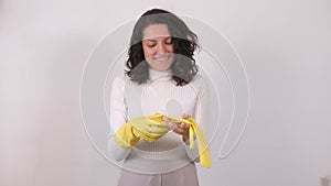 Household chores and skin protection. woman puts on protective rubber gloves and smiles