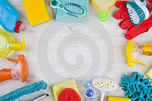 Household cleaning products on wooden background with copyspace in middle