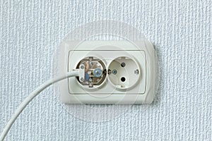 Household electrical outlet with a broken electrical plug inside. Wiring Devices