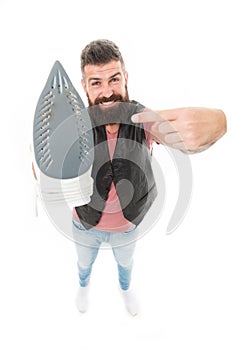 Household ironing. Bearded man pointing at clothes iron. Hipster presenting electric ironing tool. Unshaven brutal man