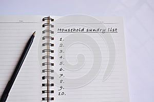 Household sundry list text on a notepad with reflection of window glass