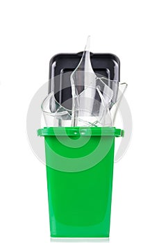 Household waste sorting concept. Green tank with glass waste isolated on white