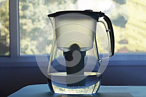 Household water purifier on a window background