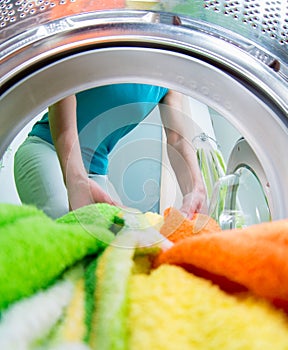 Householder loading clothing into washing machine photo