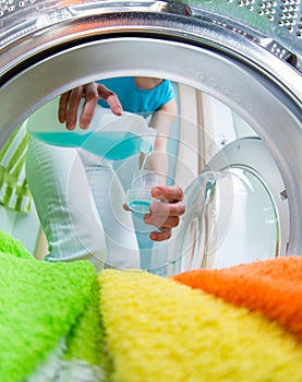 Householder woman using conditioner for washing machine