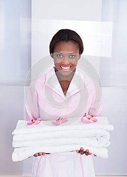 Housekeeper carrying towels in hotel