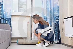 Housekeeper checking the thermostat on a radiator