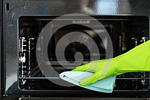 Housekeeper cleaning electric microwave using detergent and rag