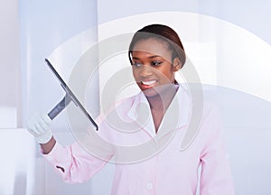 Housekeeper cleaning glass in hotel