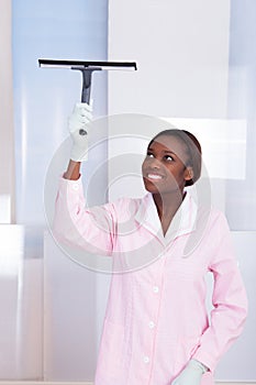 Housekeeper Cleaning Glass In Hotel photo