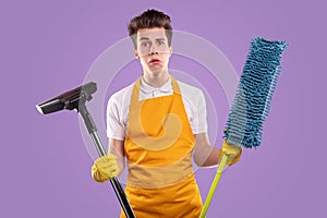 Housekeeper with mop and vacuum cleaner on purple background