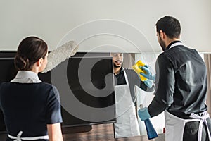 housekeepers doing cleaning in hotel room