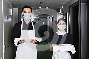 housekeepers in uniform and medical masks