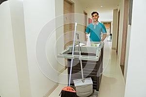 housekeepers in uniform walking pushing carts filled with cleaning supplies