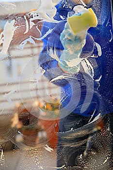 Housekeeping: cleaning the windows, Window cleaner using a squeegee, sponge and soap suds to wash a window