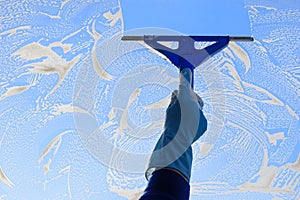 Housekeeping: cleaning the windows, Window cleaner using a squeegee, sponge and soap suds to wash a window