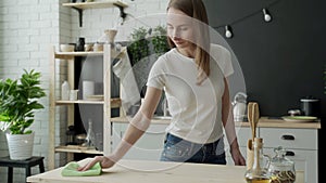 Housekeeping concept - happy woman cleaning table at home kitchen