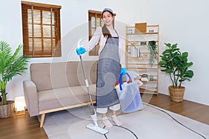 Housekeeping concept, Housemaid wear gloves and hold mop with cleaning supplies for cleanups house