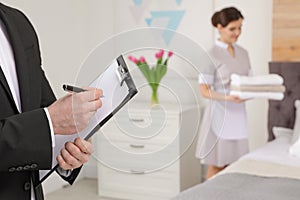 Housekeeping manager checking maid work in hotel room