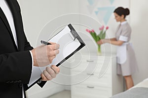 Housekeeping manager checking maid work in hotel room