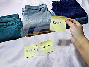 Housekeeping recycling concept. Deciding to keep, donate or discard clothing