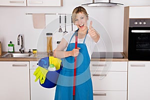 Housemaid Showing Thumbs Up In Kitchen