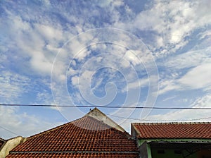 Housemate roof with blue sky and clouds background