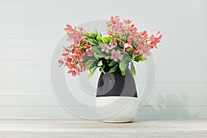 Houseplant pink flowers in vase on a shelf in the room