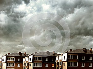 Houses against dark clouds