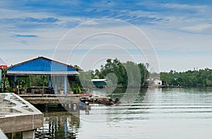 Houses along the river with long tail boats in Thailand.