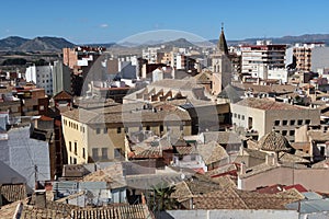 Houses around the Church of Santiago Apostol with mountains in the background. Villena, Alicante, Spain