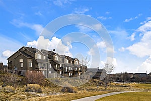 Houses with balconies and arched windows against blue sky with puffy clouds