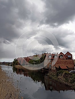 Houses on the bank of the Motlawa River under cloudy skies.  Gdansk.  Poland