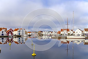 Houses and boats are reflected in the water