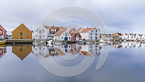 Houses and boats are reflected in the water