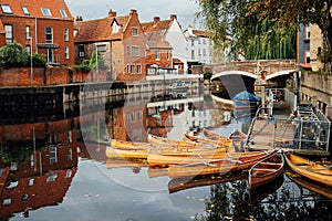 Houses and boats on the river Yare at Norwich city centre in Norfolk in autumn. Townhouses Buildings At Waterfront