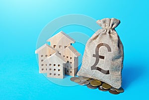 Houses and british pound sterling money bag. Increasing property value. Fair market price. Residential or commercial property